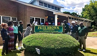 Margaret Brown (center left), Pete Brown’s wife, unveils a new sign, renaming Sonny Guy Golf Course to Pete Brown Golf Facility on May 23.