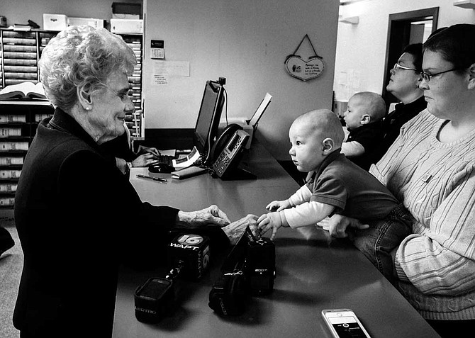 Andrea Sanders (right) holds 8-month-old Owen as he reaches across the counter to touch then-Hinds County Circuit Clerk Barbara Dunn (left). Sanders and Becky Bickett, now her wife, were at the Hinds County Courthouse applying for marriage licenses with their twin boys in March 2014, when marriage was still illegal for same-sex couples.