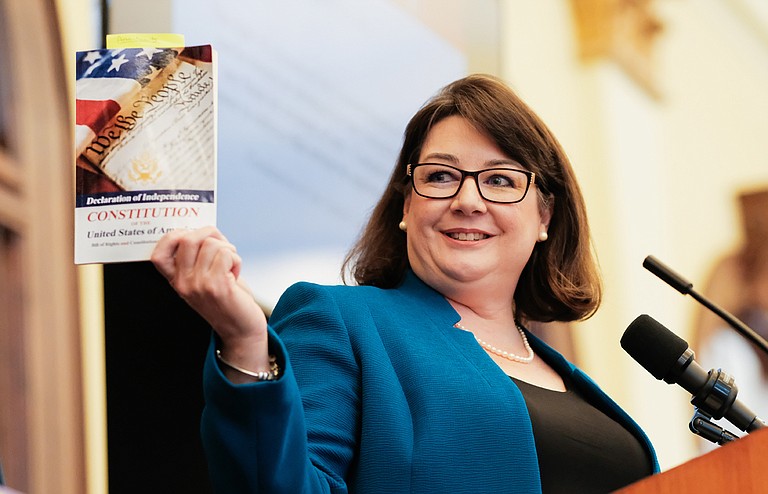 Jennifer Ingram Johnson, the president-elect of the Mississippi Bar Association, holds up a copy of the Constitution while she talks about the importance of the 19th Amendment in front of a crowd of hundreds at the League of Women Voters' 19th Amendment Celebration Luncheon in Hattiesburg on June 11, 2019.