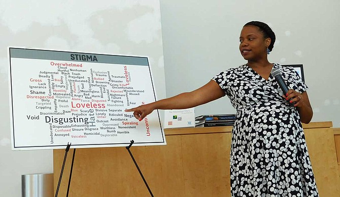 Alecia Reed-Owens, staff attorney for the Mississippi Center for Justice, points to different words that represent the stigma associated with HIV at Refill Cafe’s Friday Forum on July 12. Photo by Josh Wright