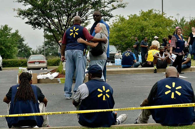 Law enforcement personnel and employees gather in a nearby parking lot after a shooting at a Walmart store Tuesday, July 30, 2019 in Southaven, Miss. Photo by Brandon Dill via AP