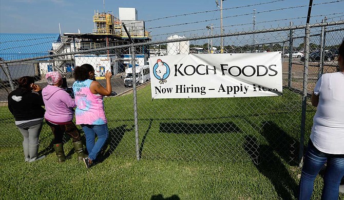 Friends, coworkers and family watch as U.S. immigration officials raid several Mississippi food processing plants, including this Koch Foods Inc., plant in Morton, Miss., Wednesday, Aug. 7, 2019. The early morning raids were part of a large-scale operation targeting owners as well as undocumented employees. Photo by Rogelio V. Solis via AP
