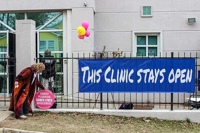 Jackson Women's Health Organization owner Diane Derzis hung up "This Clinic Stays Open" signs outside the clinic, which is now pink, after the Legislature passed an admitting-privileges law. Photo by Ashton Pittman.
