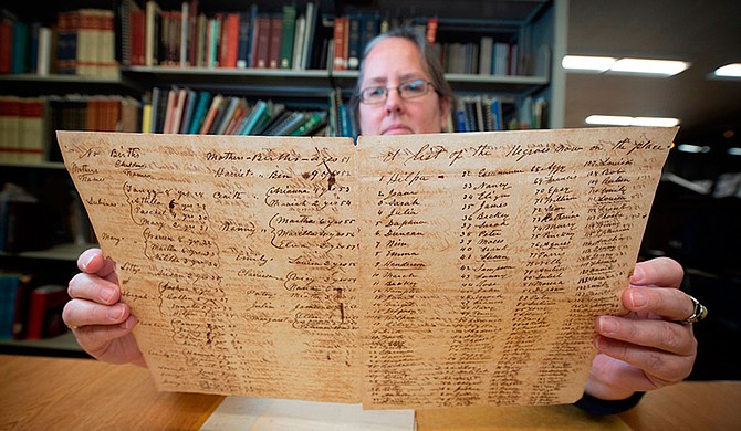 MSU Libraries Coordinator of Manuscripts Jennifer McGillan, program director for the Lantern Project, evaluates one of many historical documents for prospective digitization. If selected, a copy of the record will be made available to the public for free upon project completion. Photo by Megan Bean