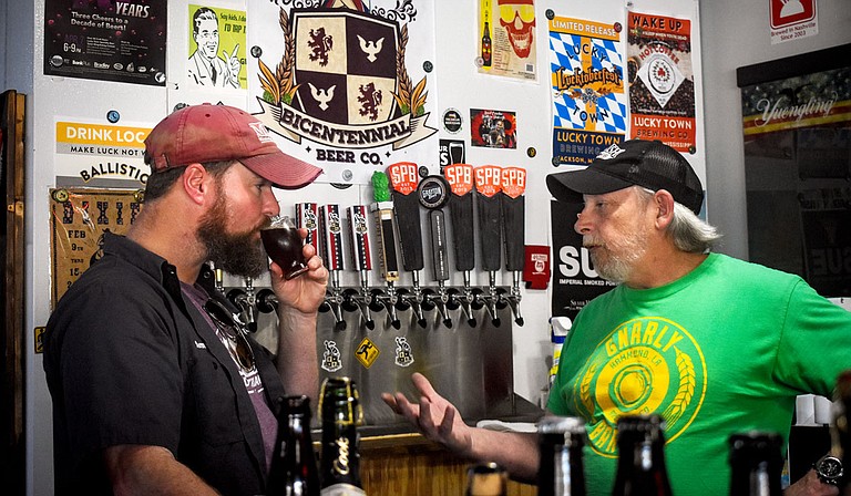 Chris Edwards (left), proprietor of Bicentennial Brewery, sips a craft beer while listening to Larry Voss (right), the owner of LD’s BeerRun. Photo courtesy Caleb McCluskey