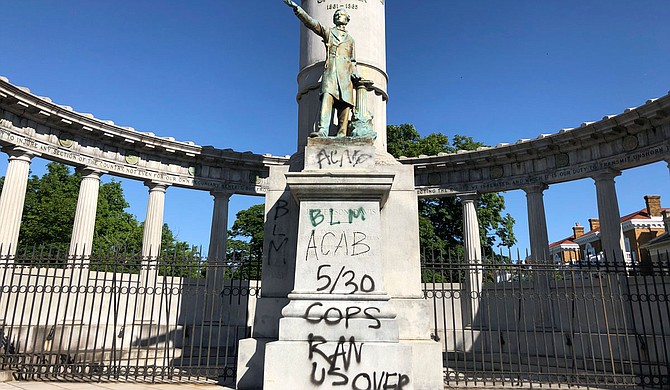 The words “spiritual genocide” in black spray paint, along with red handprints, stained the sides of a Confederate monument on the University of Mississippi campus Saturday, The Oxford Eagle reported. One person was arrested at the scene. Photo by Sarah Rankin via AP