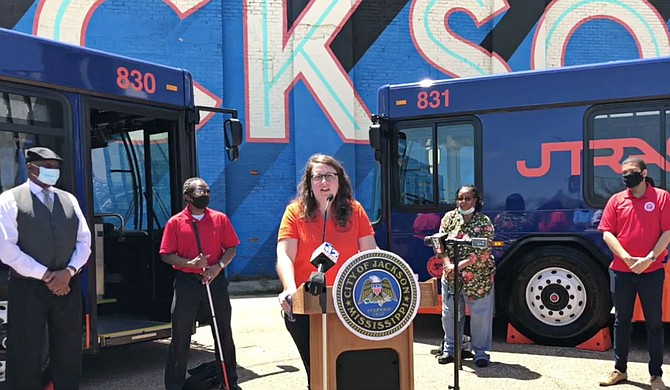 Director of Planning and Development Jordan Hillman spoke at the launch of the new transit system brand with two new buses in the background.  Photo courtesy City of Jackson.