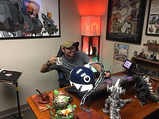 Co-owner, illustrator, designer and overall “creator of cool stuff” Jesse Labbé sits at his desk in his office, surrounded by artwork, equipment and various geek-related memorabilia. Photo by Nate Schumann.