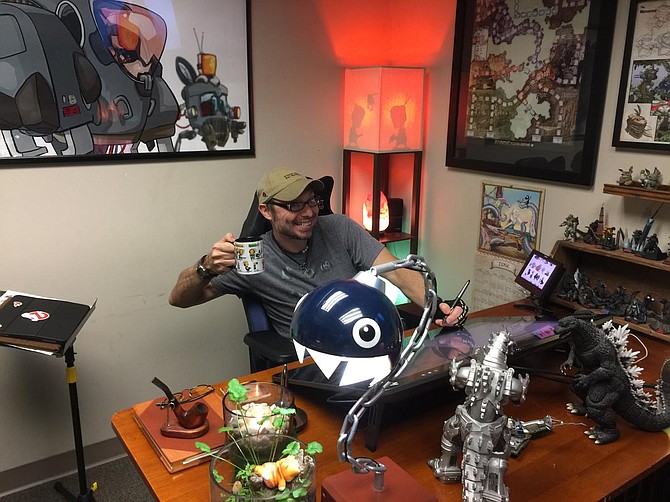 Co-owner, illustrator, designer and overall “creator of cool stuff” Jesse Labbé sits at his desk in his office, surrounded by artwork, equipment and various geek-related memorabilia. Photo by Nate Schumann.