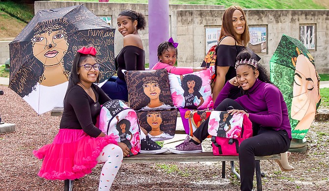 Besides custom cards, Designs by Dij creates products such as pillows, umbrellas, tote bags and more—as (from left) Madisyn Lush, Micah Lush, Harmonie Lush, Vanise Lush and Mckaylynn Lush model here. Photo courtesy Khadijah Muhammad