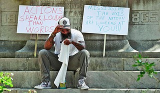 In this Monday, June 15, 2020, photo, John Lewis takes a break from protesting near the Confederate monument that stands on the Lowndes County Courthouse lawn in Columbus, Miss. Photo courtesy Claire Hassler/The Commercial Dispatch via AP