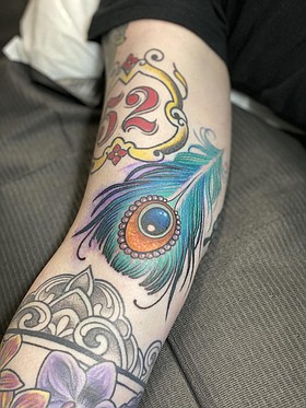 peacock feather tattoos on arm