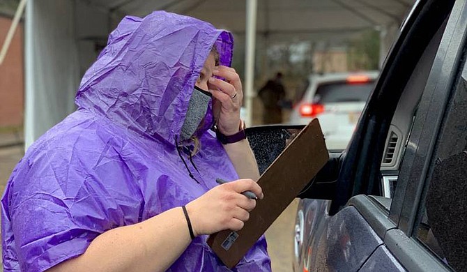 A Madison drive-through worker helps guide people through the vaccination process. The site is one of 19 drive-through clinics in the state. Photo courtesy MSDH