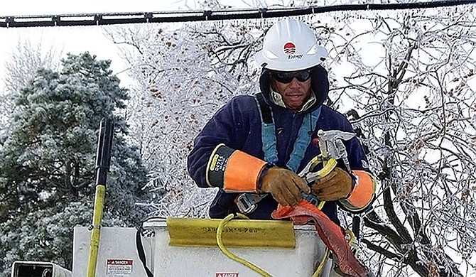An Entergy lineman works to restore power. Fallen frozen tree limbs damaged power lines across the city. Workers must remove the tree limbs before they can restore power. Photo courtesy Entergy