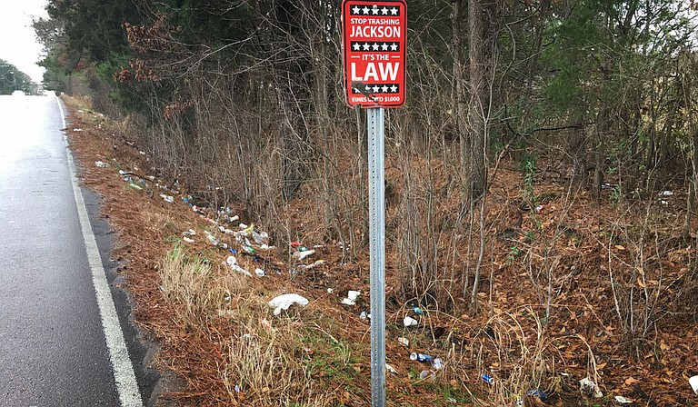 The City of Jackson put a sign on West Highland Drive saying those who throw trash beside the street will a $1,000 fine. But it seems not to be working. Photo by Kayode Crown