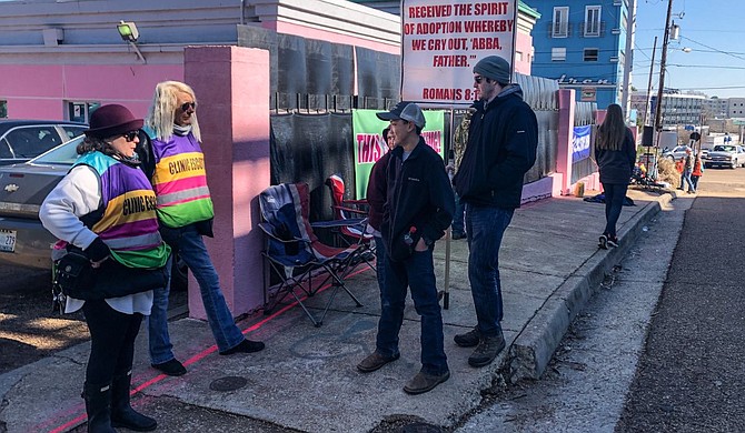 As the U.S. Supreme Court hears a Mississippi case Wednesday that could topple abortion rights nationwide, the state’s only abortion clinic was busier than ever: Volunteers continued to escort patients into the bright pink building while protesters outside beseeched women not to end their pregnancies. Photo by Ashton Pittman