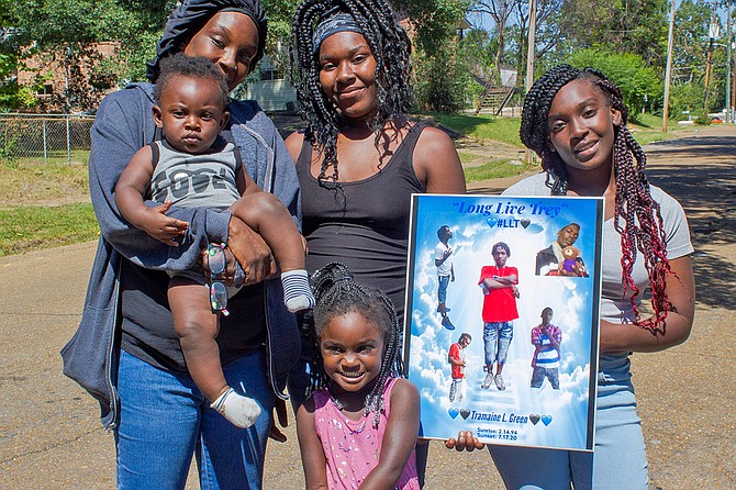 Left to right: Shaneika Green, Odella Green, Shirley Green and Sheneika’s grandchildren, Tramaine Green and Queenshley Langston, stand with a photo of her son, Tramaine Green, who died from gun violence in South Jackson in July 2020.  Photo by Acacia Clark