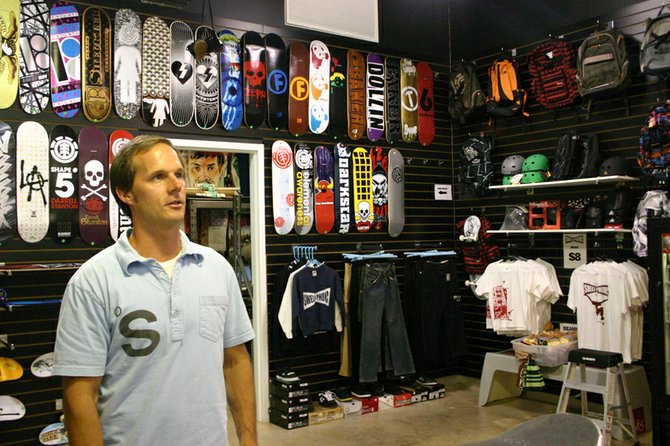 Shopkeeper Chane with designer skateboards and screenprints at Swell-O-Phonic.
