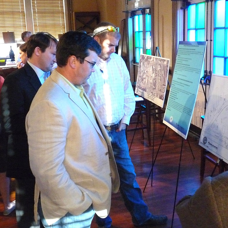 People study a map of Fondren at a public meeting to brainstorm ideas for spending grant money.