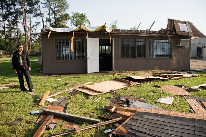 Cora Coleman, owner of Lamode Stylett and Barber Center, surveys the damage outside her business on West Northside Drive