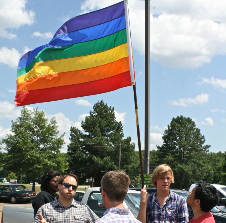 Bob Gilchrist holds a rainbow flag as gay-rights protestors organize at the Ag Museum Tuesday afternoon.