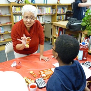 Thea Faulkner helps a student at Casey Elementary School learn math by calculating how many snacks he can buy for a certain amount of money.
