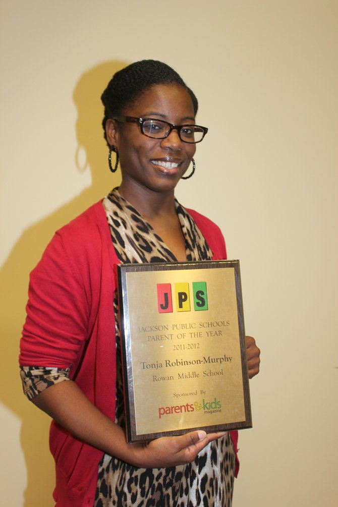Tonja Robinson-Murphy poses with her plaque for Jackson Public Schools Parent of the Year 2011-2012.