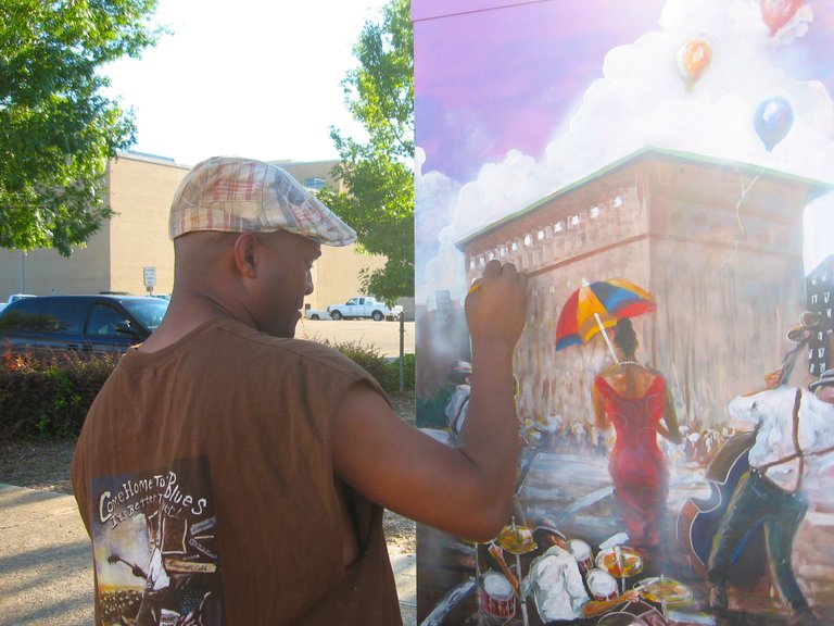Tony Davenport puts the finishing touches on his painting on a traffic signal box in downtown Jackson.