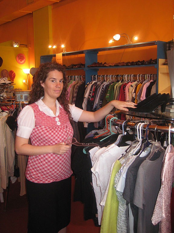 Shopkeeper Kristin Tubb restocks the clothing racks with new items in The Orange Peel.