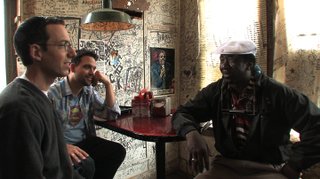 Filmmakers Roger Stolle (far left) and Jeff Konkel (middle) interview blues musician Terry "Harmonica" Bean of Pontotoc.