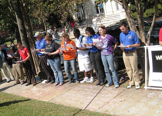 SoulForce riders and Mississippi College students recite an anonymous letter from an MC student on the sidewalk in front of Aven Hall on College Street.